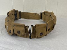 Vintage 1940s (maybe earlier) WWII web belt, army belt, bandolier, cartridge ammo belt. Stamped with a number on back. Has 10 snap pockets. Brass or copper hardware. No manufacturer's label. Adjustable size.  Measures 36" around waist as pictured.  pockets are 4.5" tall.  pockets are 2 3/4" X 4 1/2" In very good condition with some small spots, I hav not tried to clean, see pictures. Army Belt, Bullet Belt, Military Belt, Web Belt, Copper Hardware, Work Belt, Belt Vintage, Vintage Belt, Vintage Military