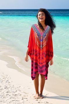 Inspired by the crimson red-orange beach sunsets in Los Cabos, this eye catching tie-dye print kaftan features a crystal embellished neckline, kimono style sleeves and side slits for an easy breezy look. A light an elegant flowing beach coverup perfect for covering up in the sunshine and versatile enough  to wear for cocktails in the evening.  PRODUCT DETAILS - V-neck with crystal work feature - Loose fit - Slip on styling - Side slits - 100% viscose crepe (opaque fabric)  SIZE & FIT - Length fr Red V-neck Kaftan With Vibrant Print, Red Beaded Summer Dresses, Orange Bohemian Cover-up For Festival, Summer Red Printed Kaftan, Red Printed Summer Kaftan, Red V-neck Beach Kaftan, Resort Festival V-neck Kaftan, Embellished V-neck Kaftan For The Beach, Red V-neck Beach Season Cover-up