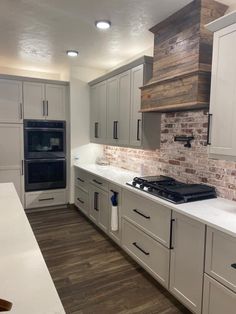 an empty kitchen with white cabinets and wood accents on the backsplash is pictured in this image