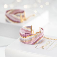 two bracelets sitting on top of a white box next to a necklace and earring