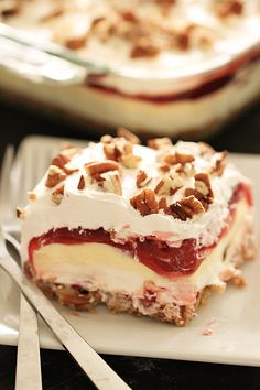 a piece of dessert sitting on top of a white plate next to fork and knife