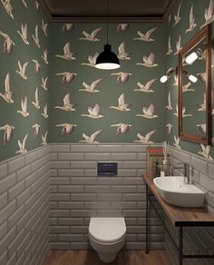 a bathroom with green wallpaper and white toilet, sink and mirror in the corner