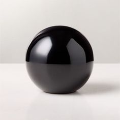 a black vase sitting on top of a white table