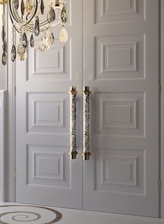 a chandelier hanging from the side of a door in a room with white walls