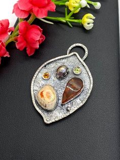 "Artisan Amber with Mexican Fire Opal pendant in sterling silver Hand-made Sterling Silver 925 Stones used: Baltic Amber, Mexican Fire Opal Purple Pearl, Peridot, Citrine Height - 2\", Width - 1 3/8\" Unique Handcrafted One-of a-kind Design Pendant Each Piece of Jewelry in my Collection is Absolutely One of a Kind! When you start wearing a piece of my jewelry you will fall in love with it more and more each day and feel that good Energy and Love that I pass into it while creating this piece of A Hand Forged Amber Sterling Silver Jewelry, Nature-inspired Freeform Silver Jewelry, Sterling Silver Cabochon Gemstones, Artisan Sterling Silver Freeform Jewelry, Sterling Silver Jewelry With Natural Stones, Sterling Silver Jewelry With Natural Stones In Freeform, Sterling Silver Jewelry With Natural Stones In Unique Shapes, Artisan Silver Pendant Gemstones, Artisan Sterling Silver Pendant Gemstones