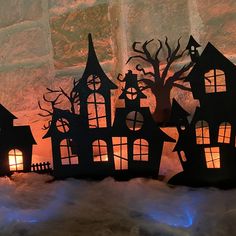 a group of paper houses sitting on top of snow covered ground