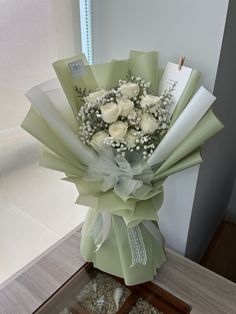 a bouquet of white roses sitting on top of a table