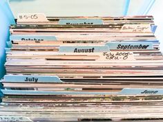 a bunch of records stacked on top of each other in a blue bin filled with papers