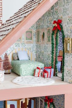 there is a doll house with christmas decorations on the shelf and presents under the stairs