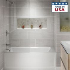 a white bath tub sitting inside of a bathroom next to a sink and mirror with an american made in usa sticker on it