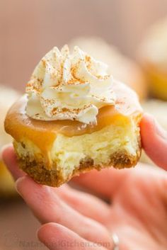 a hand holding a pastry with frosting and sprinkles on the top