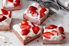 several slices of strawberry cheesecake with whipped cream and strawberries on top, next to a fork