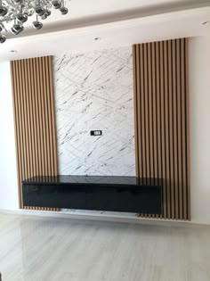 an empty room with marble walls and wooden slats on the wall, along with a black bench