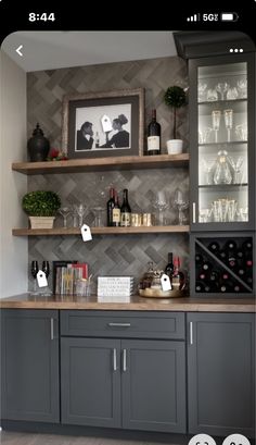 a kitchen with gray cabinets and shelves filled with wine glasses