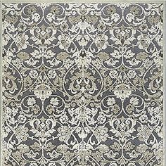 a rug with an ornate design on the front and back side, in grey tones