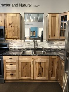 a kitchen with wooden cabinets and stainless steel appliances in the middle of it's display area