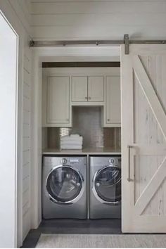 Laundry room with two front-loading washing machines and a stack of white towels on a countertop. Florida Beach House, Small Laundry Room Organization, Casa Clean, Room Storage Diy, Barn Door Closet, Laundry Room Closet, Farmhouse Laundry, Farmhouse Laundry Room, Charming Farmhouse