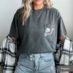 Looking for a cute halloween or fall shirt? You've come to the right place! These cute skeleton pocket tees are a great choice if you're going trick or treating or celebrating spooky season! Our unisex tees are very cute and comfy! You can pair them with your favourite leggings, tuck them into your jeans, or tie them up in a knot. We love this casual style and know you will too! MATERIALS AND SIZING These unisex tees are made with 100% soft cotton and excellent quality print. They fit nice and l Edgy Fall Tops With Pockets, Edgy Tops With Pockets For Fall, Trendy Crew Neck T-shirt With Pockets, Casual Skull T-shirt For Fall, Fall Crew Neck T-shirt With Pockets, Cute Crew Neck Top With Pockets, Cute Fall Tops With Pockets, Fall Skull Print Cotton T-shirt, Fall Cotton T-shirt With Skull Print