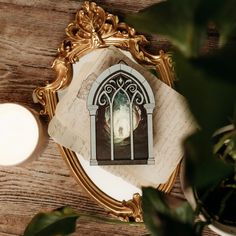 a mirror with an image of a person standing in front of it on top of a wooden table next to a candle