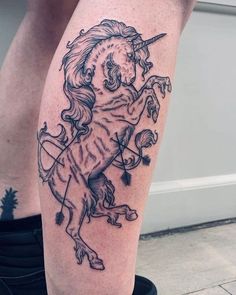 a black and white tattoo of a unicorn on the leg