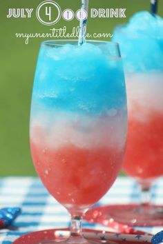 two glasses filled with red, white and blue drink sitting on top of a checkered table