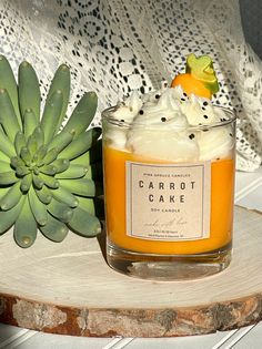 a candle sitting on top of a wooden table next to a succulent plant