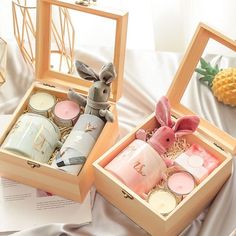 two wooden boxes filled with candles on top of a bed