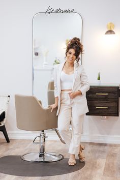 a woman standing in front of a chair with her hair dryer on the floor