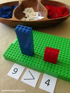 a wooden spoon sitting on top of a table next to a lego board with numbers