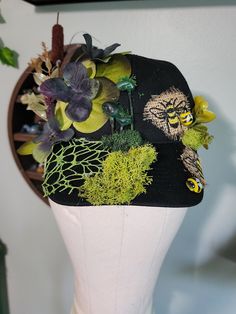 Witchy Summer Soltice, Lithia, baseball style hat, cap, adorned with flowers, moss, mushrooms, faux bees and summer folage. Base color: Black  Handmade by Symön  Size: One Size, adjustable snaps No returns or refunds. Sold as is. Witchy Summer, Decorated Hats, Villa Park, Mannequin Heads, Black Flower, Baseball Hat, Hat Cap, Trucker Cap, Hat Fashion