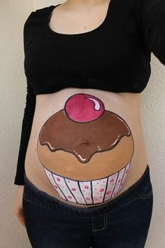 a pregnant woman's stomach with an image of a cupcake painted on it