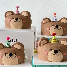 three birthday cakes made to look like bears with hats on their heads, and one bear wearing a party hat