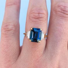 a woman's hand with a blue and white stone ring on top of it