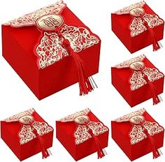 six red boxes with white designs and tassels