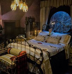 a bedroom with a large bed and chandelier hanging from it's ceiling