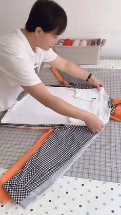 a woman is sewing clothes on the floor