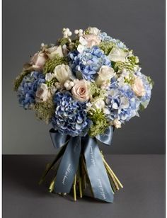 a bouquet of blue and white flowers on a gray background with the word love written below it