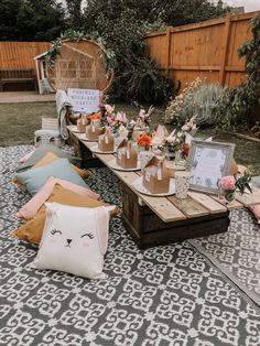 an outdoor picnic table set up with mason jars, flowers and other items on it