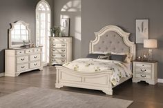 a white bed sitting in a bedroom next to a dresser with drawers and mirror on top of it