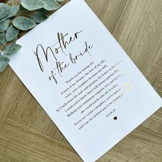 a mother of the bride poem on top of a white paper next to some leaves