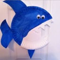 a paper plate shaped like a shark hanging on a door