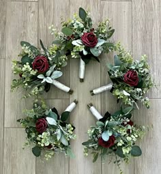 a circular arrangement of flowers and candles on a wooden floor in the shape of a cross