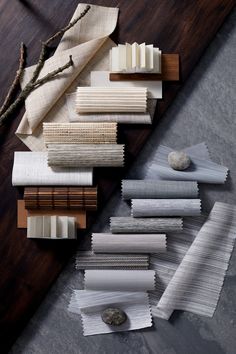 several different types of fabric laid out on a table with rocks and branches in the background