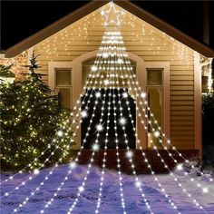 a christmas tree is lit up in front of a house