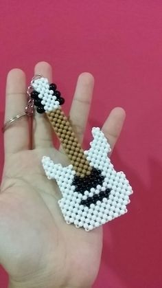 a hand holding a beaded keychain with a dog on it