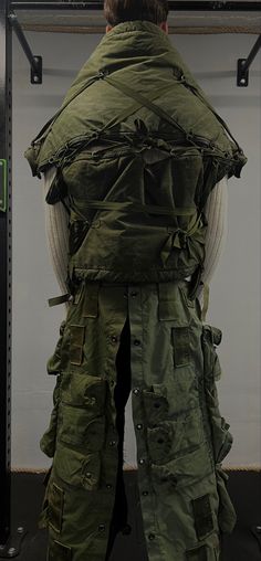 the back of a man's green jacket hanging on a rack in a room