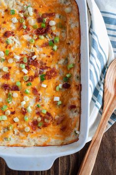 a casserole dish with corn, peas and bacon in it on a wooden table