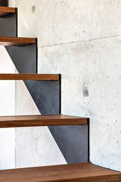 a set of three wooden shelves sitting next to each other on top of cement walls