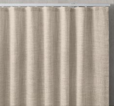 a white curtain hanging on the side of a wall