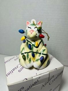 a cat figurine sitting on top of a box